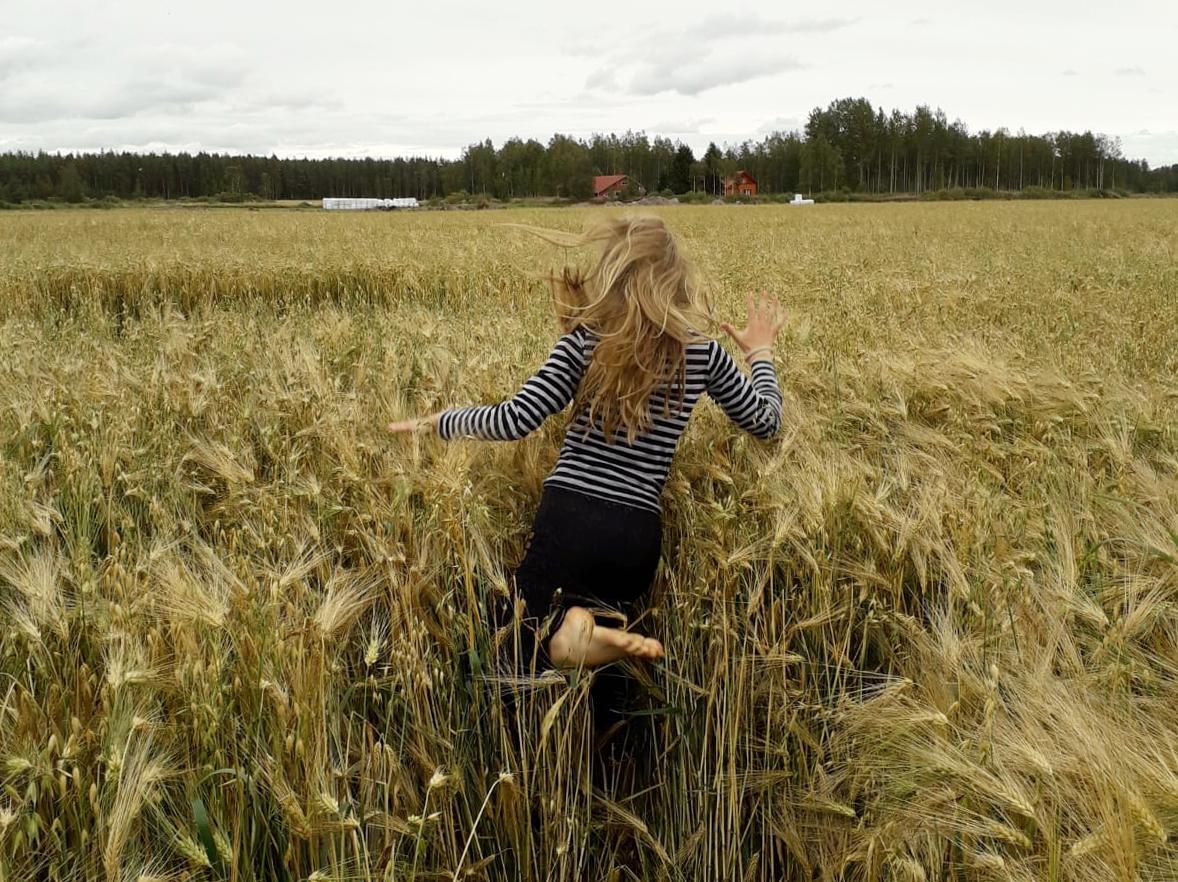 Tyttö juoksee vehnäpellolla. EHYT ry toimii Tampereella ja Seinäjoella.