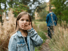 A child standing on s forest trail.