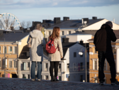Ihmisiä Tuoniokirkon portailla katselemassa kaupunkimaisemaa.
