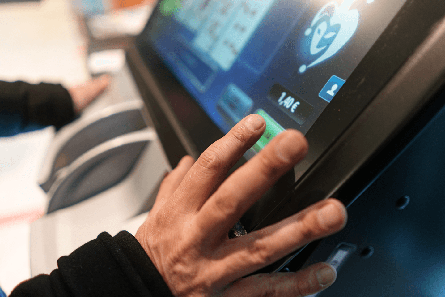 Närbild på en spelautomat och en spelares händer.
