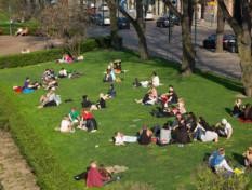 Ihmisiä kesällä Esplanadin puistossa istuskelemassa.